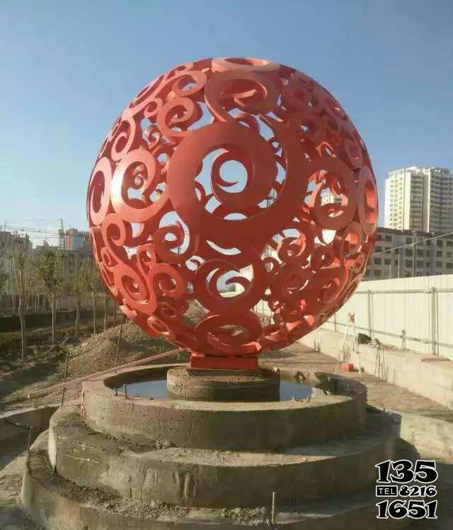鏤空球雕塑-公園不銹鋼噴泉中的紅色鏤空球雕塑 鏤空球雕塑-公園不銹鋼噴泉中的紅色鏤空球雕塑高清圖片
